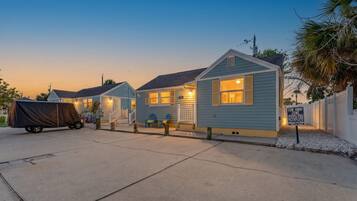 A row of small, single-story houses with a covered vehicle in the foreground.