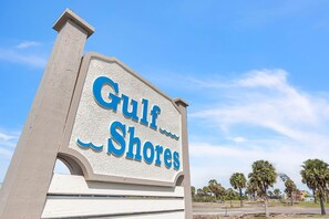 A sign for 'Gulf Shores' with a clear sky and palm trees in the background. - Gulf Shores #402 (Indian Shores)