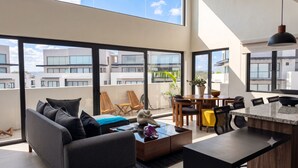 En moderne lejlighed med balkon, spiseplads og køkken.