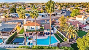 Un quartier résidentiel doté d’une piscine, de palmiers et de maisons.