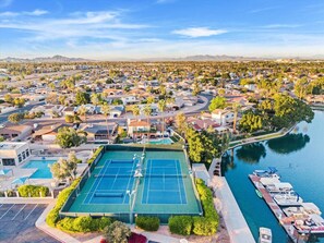 Ein Blick von oben auf eine Wohngegend mit Tennisplatz, Marina und Fluss.