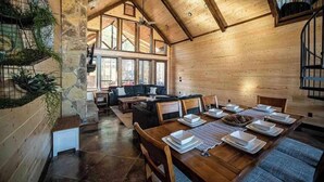 Un intérieur en bois comprenant un coin repas, un canapé et un escalier.