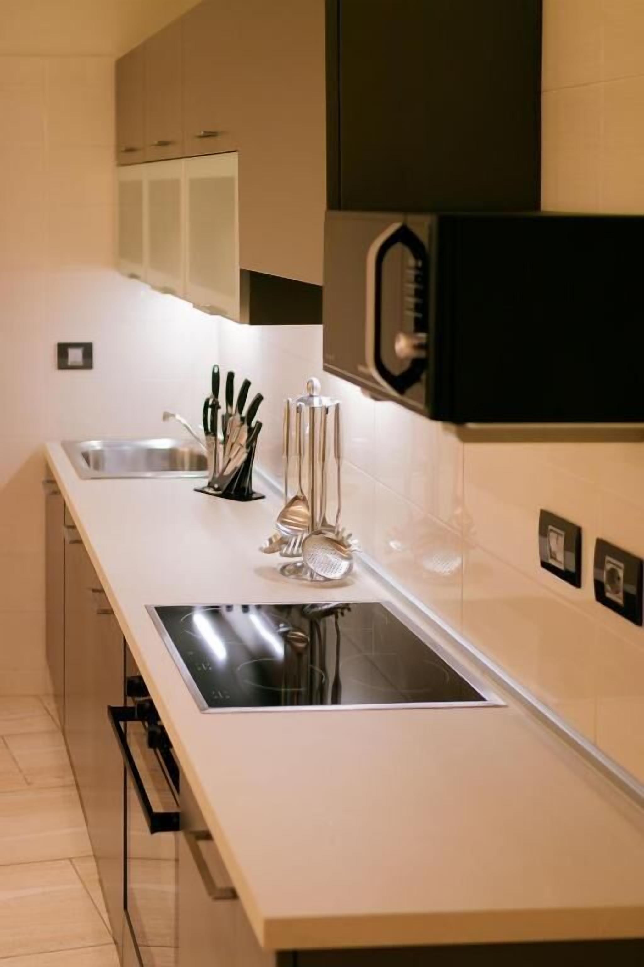Una cocina moderna con estufa integrada, un lavaplatos y un bloque para cuchillos.