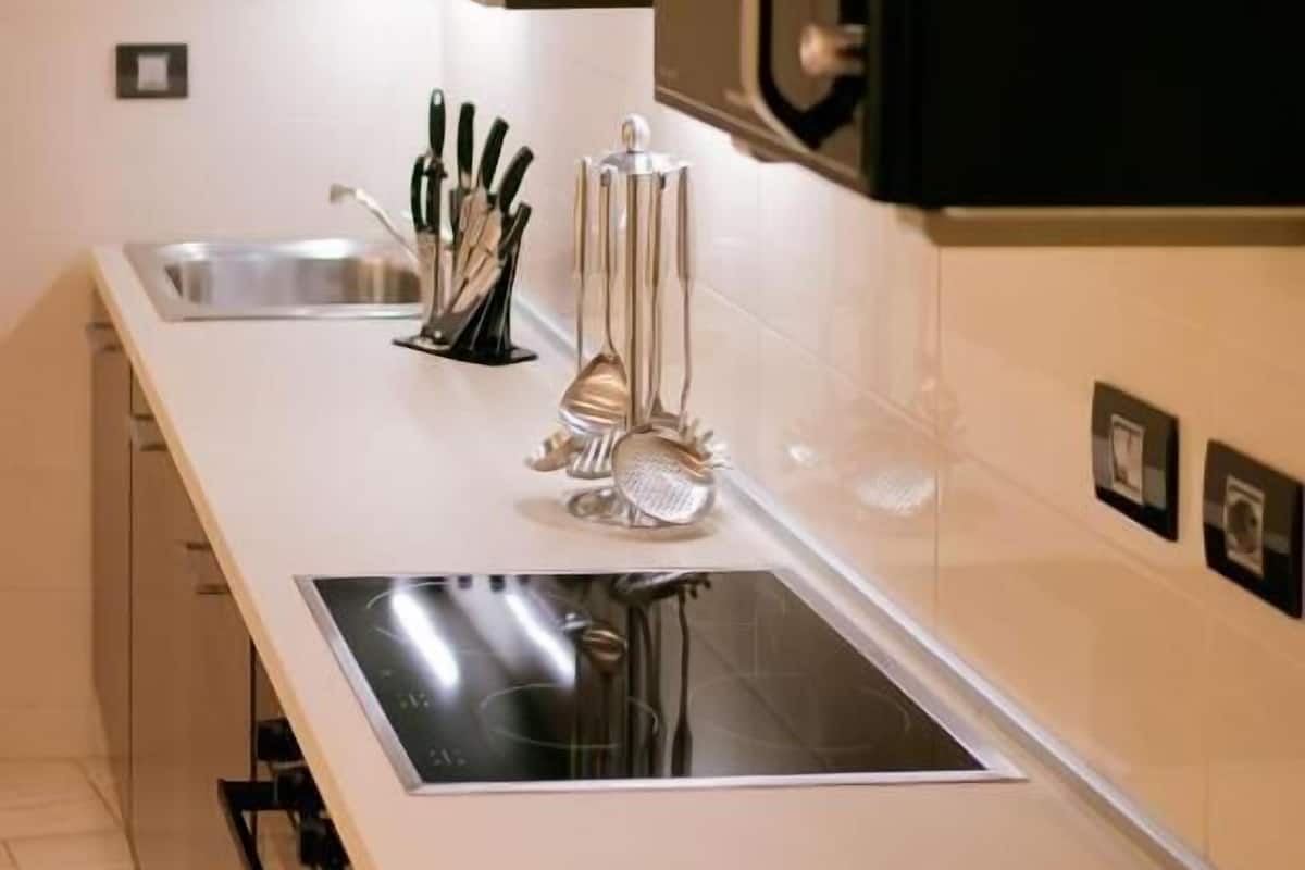 Una cocina moderna con estufa integrada, un lavaplatos y un bloque para cuchillos.