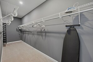 A laundry area with a hanging rack, an ironing board, and a ceiling-mounted drying rack. - Delightful 3-bedroom house with AC in vibrant Atlanta (Atlanta)