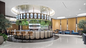 A modern bar area with a circular design, bar stools, and seating. - Luxury E11EVEN Studio 50th Floor with Elite Amenities (Miami)