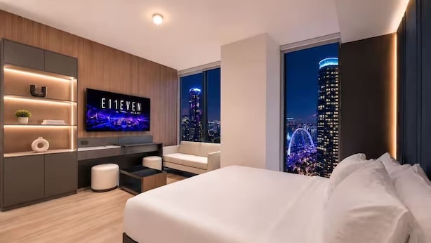 A modern hotel room with a large bed, a TV, a desk, and a city view. - Luxury E11EVEN Studio 50th Floor with Elite Amenities (Miami)