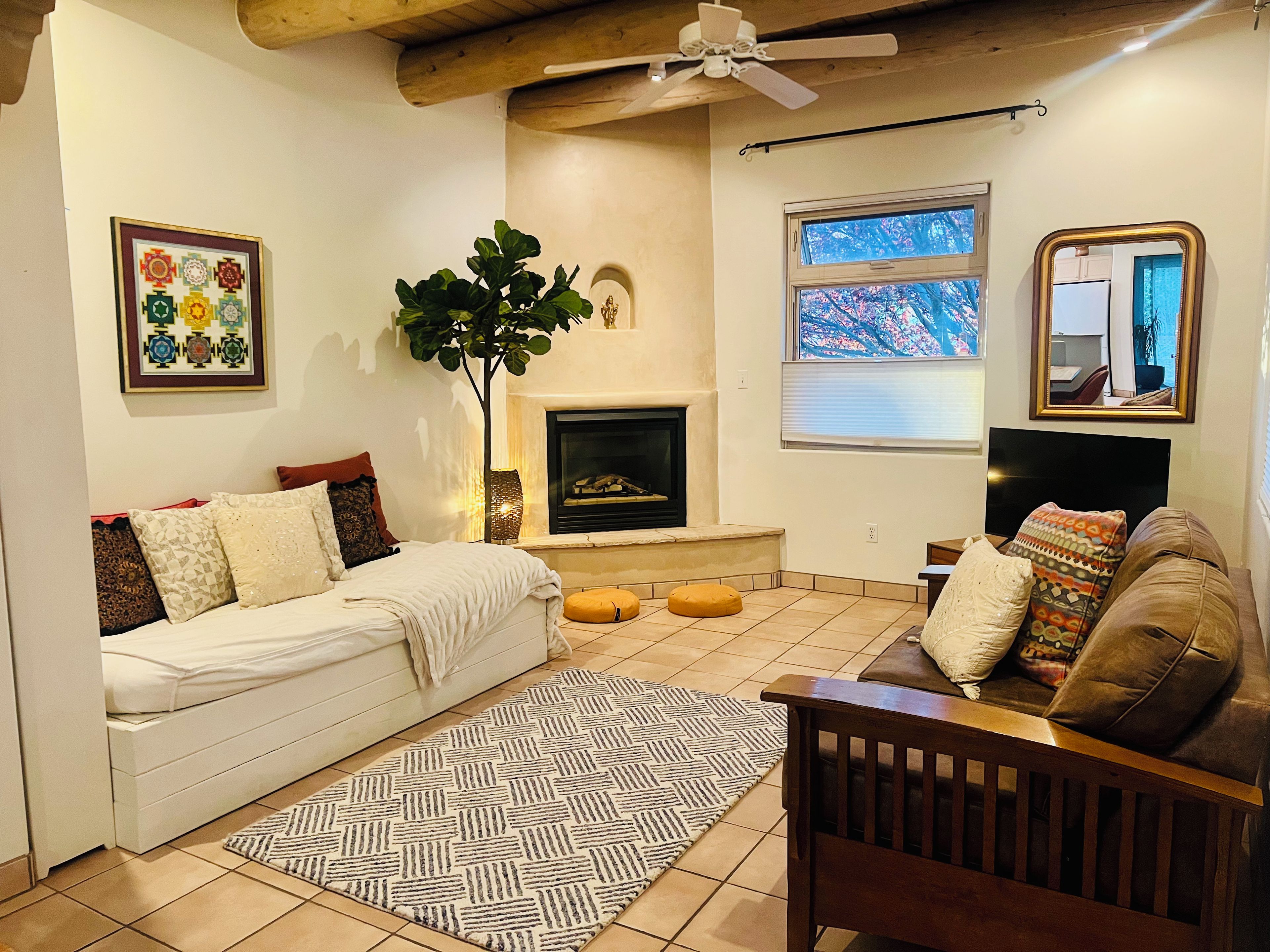 Una sala de estar acogedora con chimenea, un sofá, una silla y un ventanal con vistas.