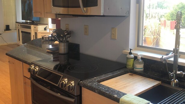 A kitchen with a microwave, stove, and sink, wooden cabinets, and a window with a view. - Beautiful In-law suite in Palmyra PA. No Cleaning Fees. (Palmyra)
