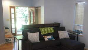 A modern living room with a sectional sofa, a glass coffee table, and a view of the outdoors through a door. - Beautiful In-law suite in Palmyra PA. No Cleaning Fees. (Palmyra)