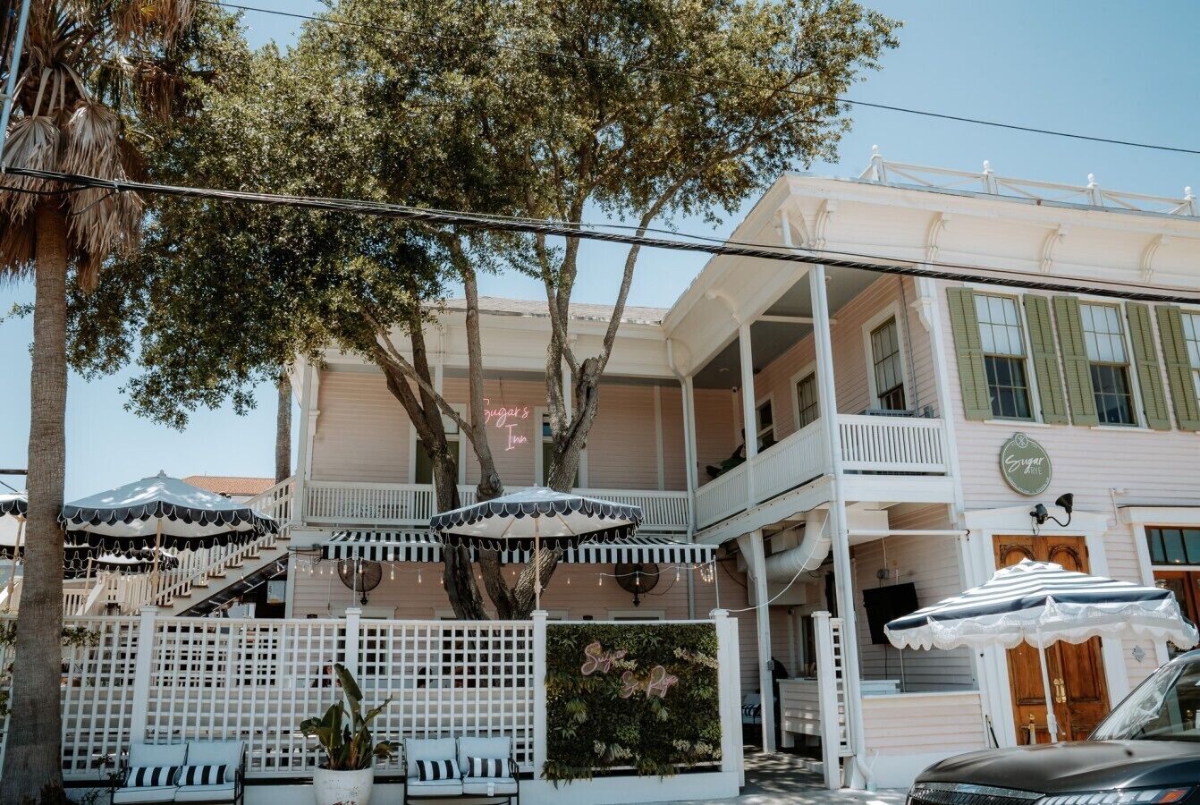 A two-story building with balconies, outdoor seating, and string lights.