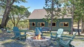 A lodge with a fire pit, outdoor seating, and a view of the surrounding forest. - Barndo Hideaway at Hy Sun Ranch (Auburn)
