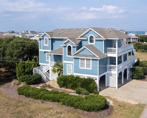A two-story house with a balcony, a front porch, and a driveway. - Oceanside, Pool, Walk to Beach! Pet Friendly! (Kitty Hawk)