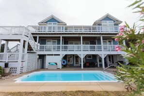 A two-story house with a pool, a covered patio, and a staircase leading to the upper level. - Oceanside, Pool, Walk to Beach! Pet Friendly! (Kitty Hawk)