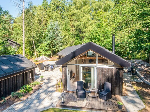 A modern cabin with a deck, glass doors, and a chimney. - 5 Star Holiday Home in Ans By (Ans)