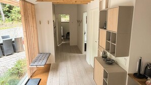 En modern inredning med en träbänk, inbyggda hyllor och utsikt över omgivningen.