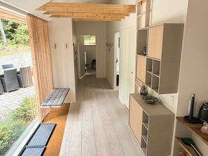 A modern interior with a wooden bench, built-in shelves, and a view of the outdoors. - 5 Star Holiday Home in Ans By (Ans)