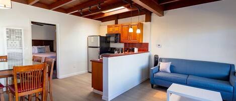 A compact living space with a kitchenette, a dining area, and a seating area.