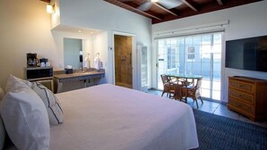 Una habitación de hotel con cama, baño, zona de comedor y televisión.