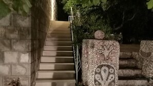 A staircase with stone steps leading upwards, surrounded by greenery and potted plants. - Old Town Bay Cavtat with Sea View (Cavtat)