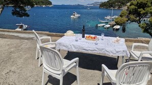 A table set with a bottle, fruit, and glasses, overlooking a marina with boats. - Old Town Bay Cavtat with Sea View (Cavtat)