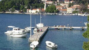 A marina with several boats docked, a pier extending into the water, and buildings in the background. - Old Town Bay Cavtat with Sea View (Cavtat)