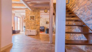 A stone-walled interior with a staircase, a wooden floor, and a framed picture on the wall. - Villa with swimming pool (Vrgorac)