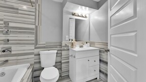 Ein modernes Badezimmer mit Toilette, Waschbecken und Dusche.