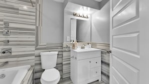 Ein modernes Badezimmer mit Toilette, Waschbecken und Dusche.