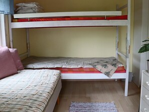 A bunk bed with a lower bunk and a mattress with a floral pattern. There is a wooden floor and a small rug. - 5 Person Holiday Home in Bastad (Bastad)