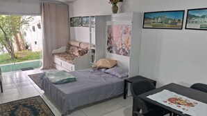 A room with a bed, a desk, a chair, a table, and a window. - Studio 81 (Rio de Janeiro)