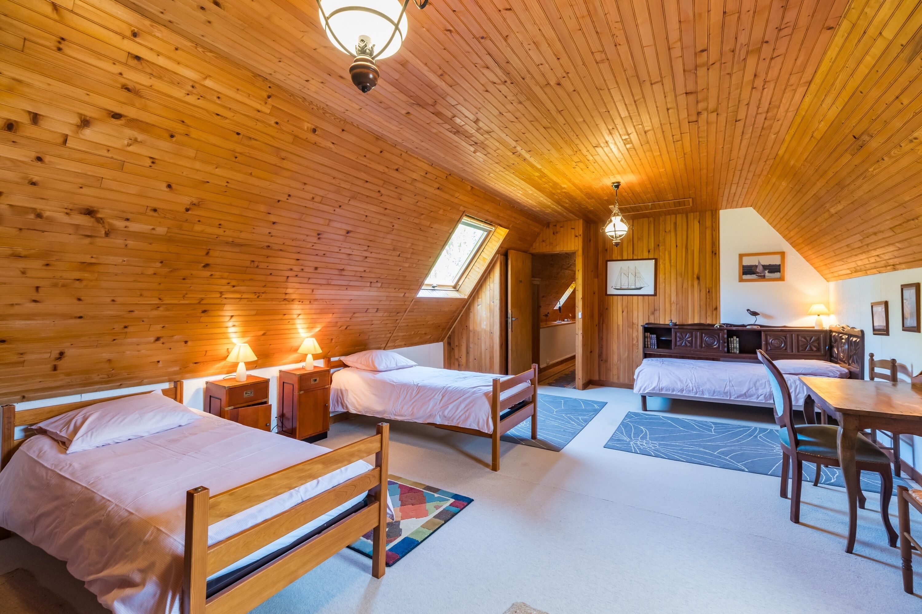 Ein gemütliches Blockhaus mit Holzwänden, zwei Betten, einem Esstisch und einer kleinen Küchenzeile.