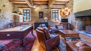 A cozy room with a pool table, leather sofas, a fireplace, and stone walls. - Le Manoir - Plouguiel (Plouguiel)