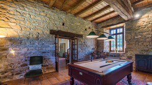 A room with a pool table, a chair, a lamp, and a window with a view. - Le Manoir - Plouguiel (Plouguiel)