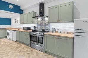 Eine moderne Küche mit Edelstahlherd, Backofen und integriertem Mikrowellenherd.