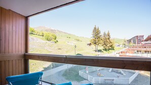 A balcony with a view of a playground and buildings. - Le Zodiaque - Station de ski accessible à pied (Villarembert)