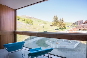 Ein Balkon mit Blick auf einen Spielplatz und Gebäude.