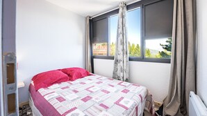 A bedroom with a bed, a window, and a radiator. - Le Zodiaque - Station de ski accessible à pied (Villarembert)