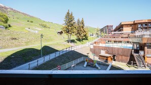 A ski resort with a wooden building, a playground, and a clear sky. - Le Zodiaque - Station de ski accessible à pied (Villarembert)