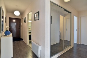 A hallway with a white radiator, a blue vase, and a framed picture on the wall. - L'Échappée Dinardaise - À 400 m de la plage (Dinard)
