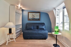 A bedroom with a bed, a painting, a lamp, and a window. - Le Cocon des Remparts - Au coeur de l'intramuros (Saint-Malo)