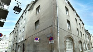 A corner building with multiple windows and a no parking sign. - Le Cocon des Remparts - Au coeur de l'intramuros (Saint-Malo)