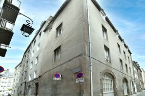 A corner building with multiple windows and a no parking sign. - Le Cocon des Remparts - Au coeur de l'intramuros (Saint-Malo)