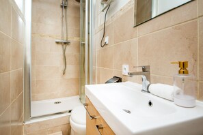 A modern bathroom with a shower, toilet, and sink. - Le Nid Choletais - Au centre-ville de Cholet (Cholet)