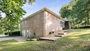 A brick house with a front porch, steps leading to the entrance, and a small garden area. - Studio w/ private garage and washer/dryer (Mt. Juliet)