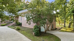 A brick house with a front yard, a garage, and a staircase leading to the entrance. - Studio w/ private garage and washer/dryer (Mt. Juliet)