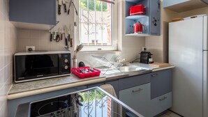 Une cuisine équipée d’un four à micro-ondes, d’un évier et de placards.