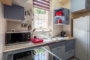 Une cuisine équipée d’un four à micro-ondes, d’un évier et de placards.