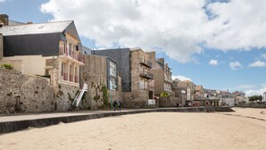 A coastal building with a stone facade, a balcony, and a staircase leading to the entrance. - Bel Horizon Marin - Magnifique vue mer (Saint-Malo)