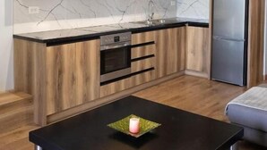 Una cocina moderna con armarios de madera, salpicadero de mármol y encimera negra.